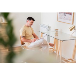 Mann im Arbeitsbereich zu Hause mit Glastisch und Holzbeinen